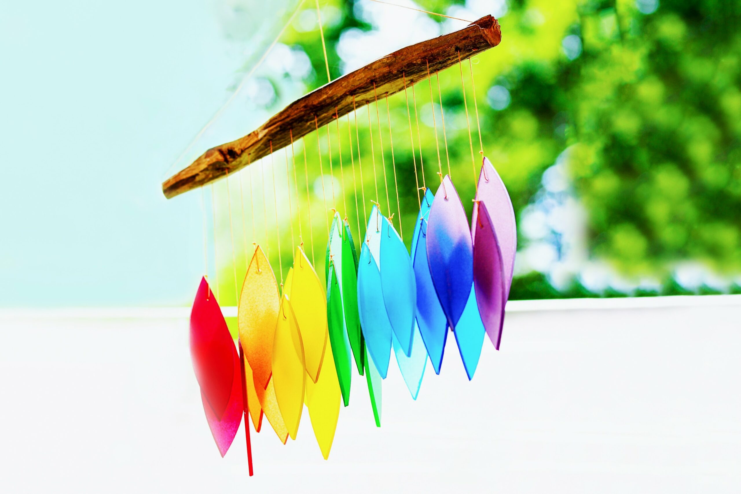 Rainbow glass wind chimes or windchime on nature background. Feng shui symbol. Copy space Feng Shui 5 Elemente